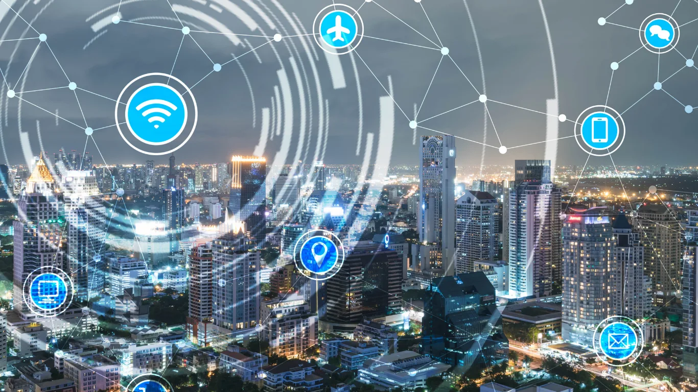 Illustrated smart city with interconnected icons (Wi‑Fi, cloud, airplane, phone, location pin, email) forming a network across skyline.