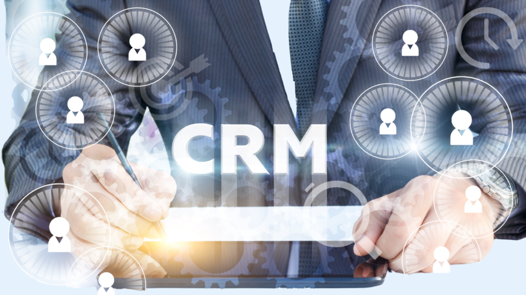 Hands using a tablet to manage CRM, with floating circular user/profile icons around gear graphics