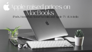 Hero image of a silver MacBook on a desk with a keyboard, mouse, and small plants, captioned with an article about Apple raising MacBook prices.