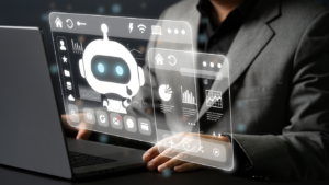 Person at a laptop with a floating holographic dashboard showing a robot avatar, charts, and icons (tech/concept image).